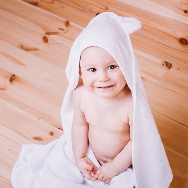 Petit bébé souriant dans sa cape de bain
