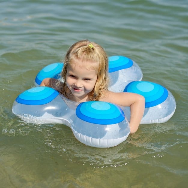 petite fille qui nage avec l'aide de sa bouée