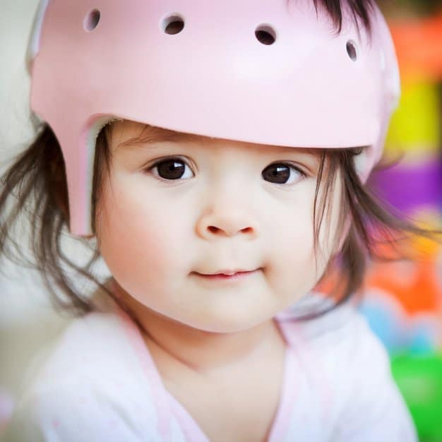 Bébé qui porte un casque rose de vélo