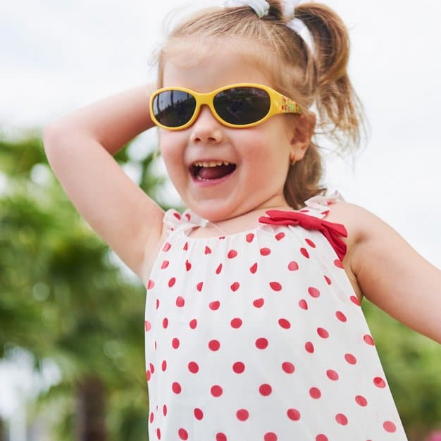 Petite fille heureuse qui court avec ses lunettes de soleil