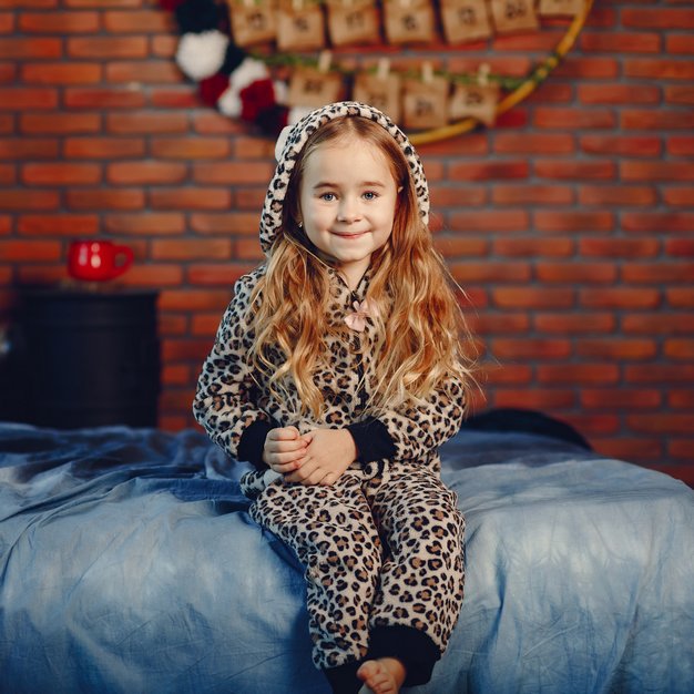 petite fille avec son pyjama sur son lit