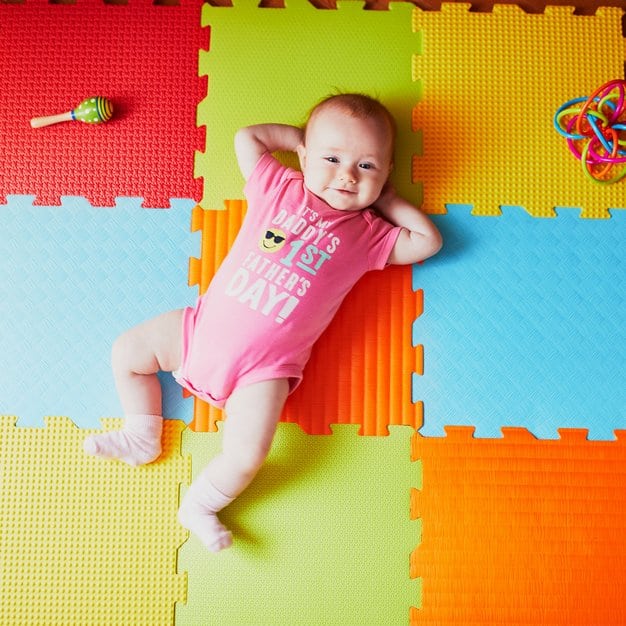 Bébé de 4 mois sur un tapis de jeu